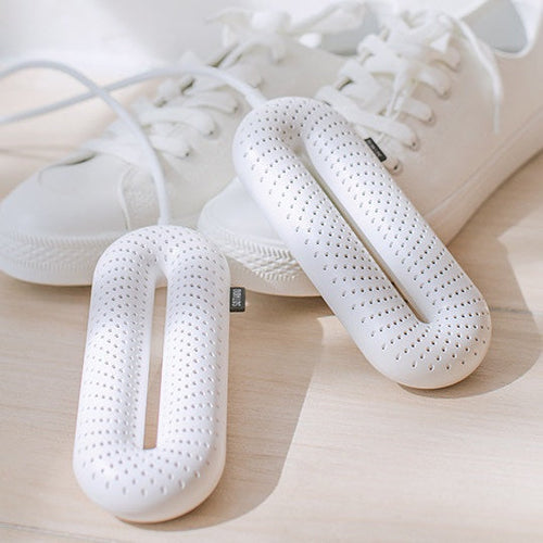 DRYVA Dryer bredvid vita sneakers på trägolv