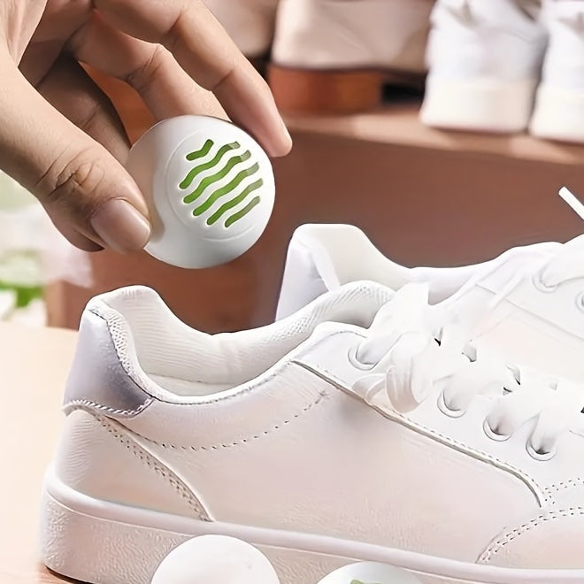 DRYVA Fresh Balls hålls över en vit sneaker